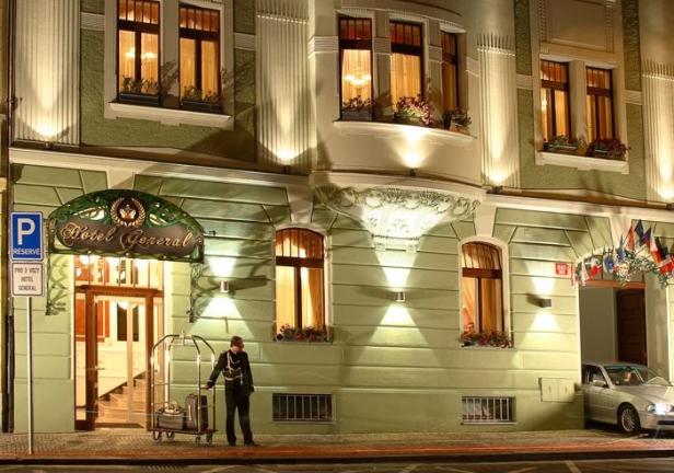 Ein Hotelpage steht vor dem „Hotel General“ mit einem Gepäckwagen.