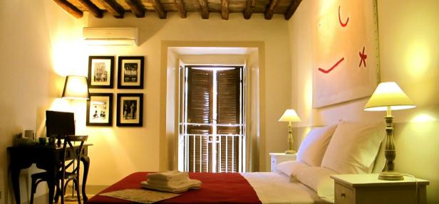 Ein Schlafzimmer mit einem Doppelbett, einem Schreibtisch und einem abstrakten Gemälde.