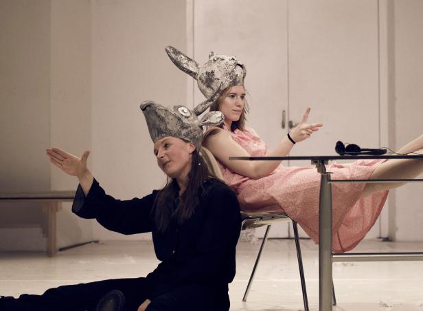 Zwei Frauen mit Hasenmasken posieren in einem hellen Raum.