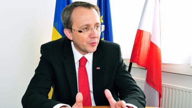 Bürgermeister Matthias Stadler Ein Mann in Anzug und Krawatte sitzt vor Flaggen der Ukraine, EU und Polen.