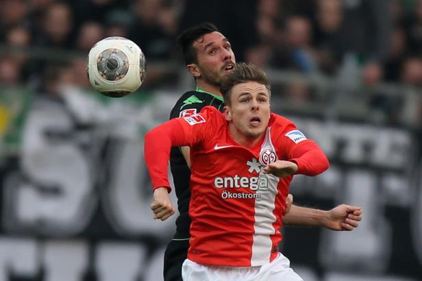 Zwei Fußballspieler kämpfen um einen Ball in der Luft.