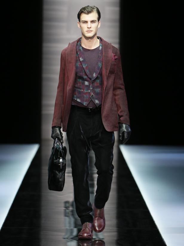 Ein Mann in einem Anzug mit Weste und Jacke auf einem Laufsteg.