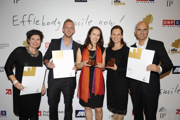 Fünf Personen posieren mit Urkunden und Trophäen bei den Effie Awards Austria.