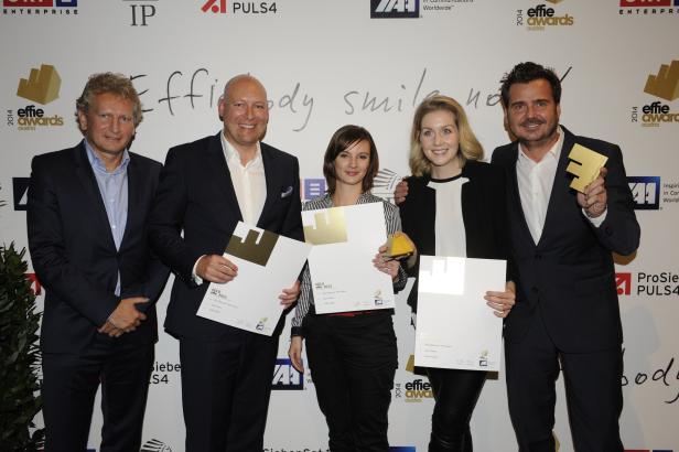 Fünf Personen posieren mit goldenen Effie Awards Auszeichnungen für Opel Österreich.