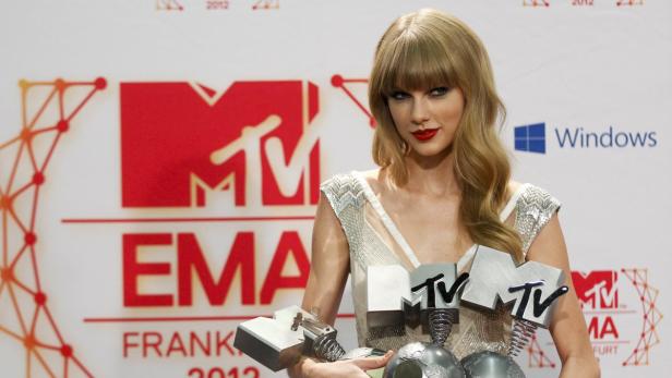 Taylor Swift hält mehrere MTV EMA Awards in den Händen.