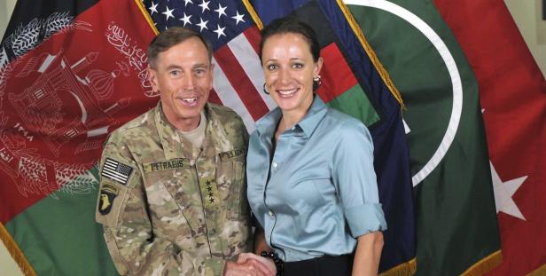 David Petraeus und Paula Broadwell schütteln sich vor verschiedenen Flaggen die Hände.