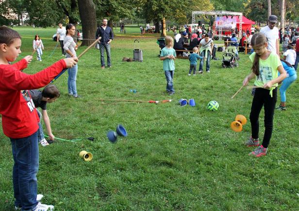 Kinder spielen im Park mit Diabolos.