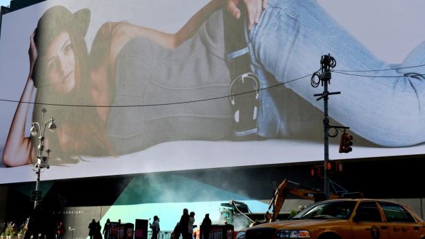 Ein großes Werbeplakat mit einer Frau in Jeans und Hut in New York City.
