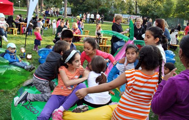 Eine Gruppe Kinder spielt auf Hüpfburgen im Freien.