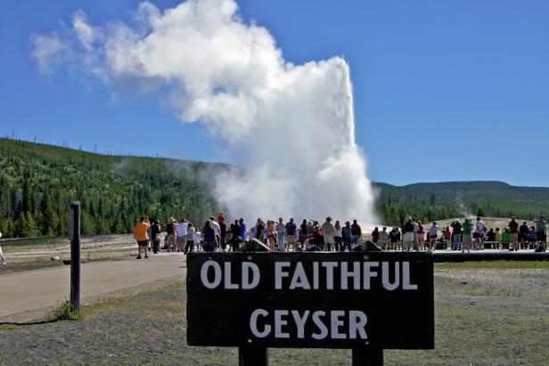 Eine Menschenmenge beobachtet den Ausbruch des Geysirs Old Faithful im Yellowstone-Nationalpark.
