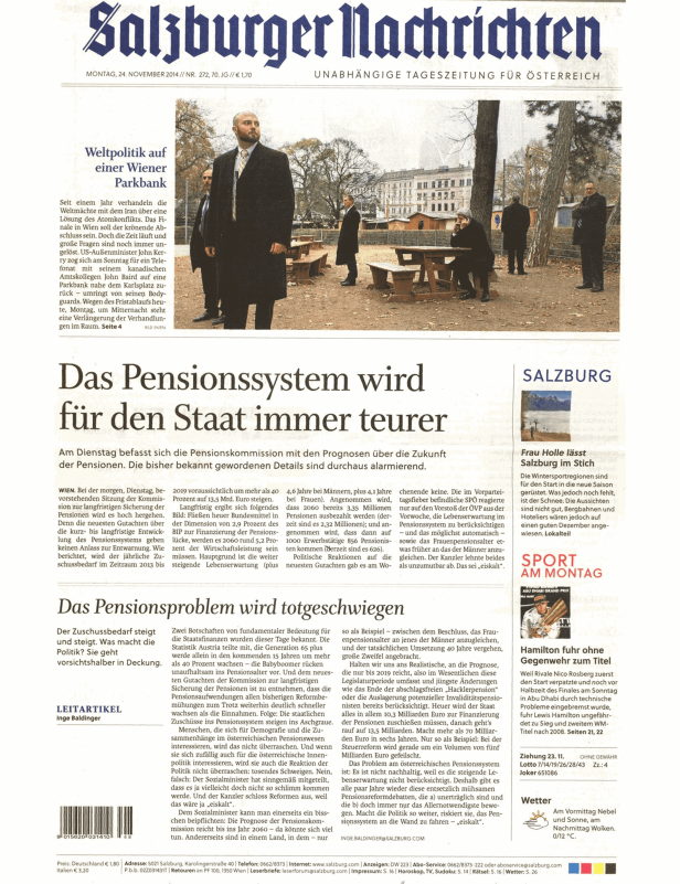 John Kerry telefoniert auf einer Parkbank in Wien, umringt von Bodyguards.