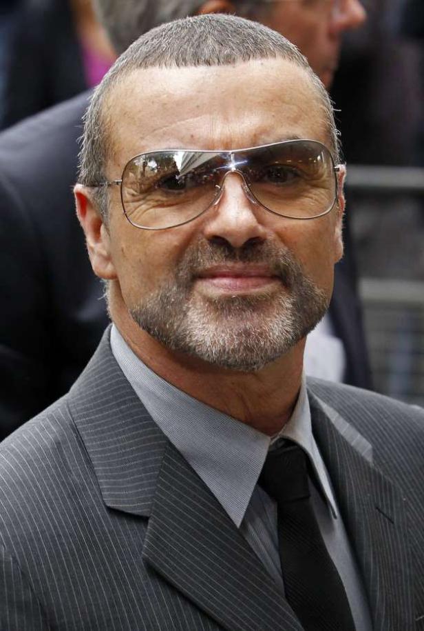 George Michael mit Anzug und Sonnenbrille.