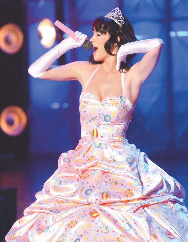 Katy Perry tritt in einem bonbonfarbenen Kleid und einer Tiara auf der Bühne auf.