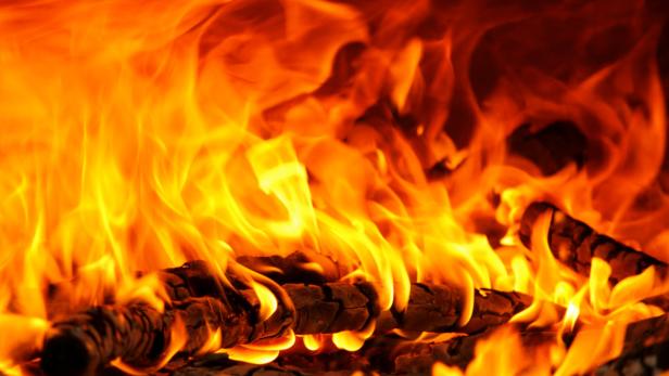 Flammen schlagen um brennendes Holz.