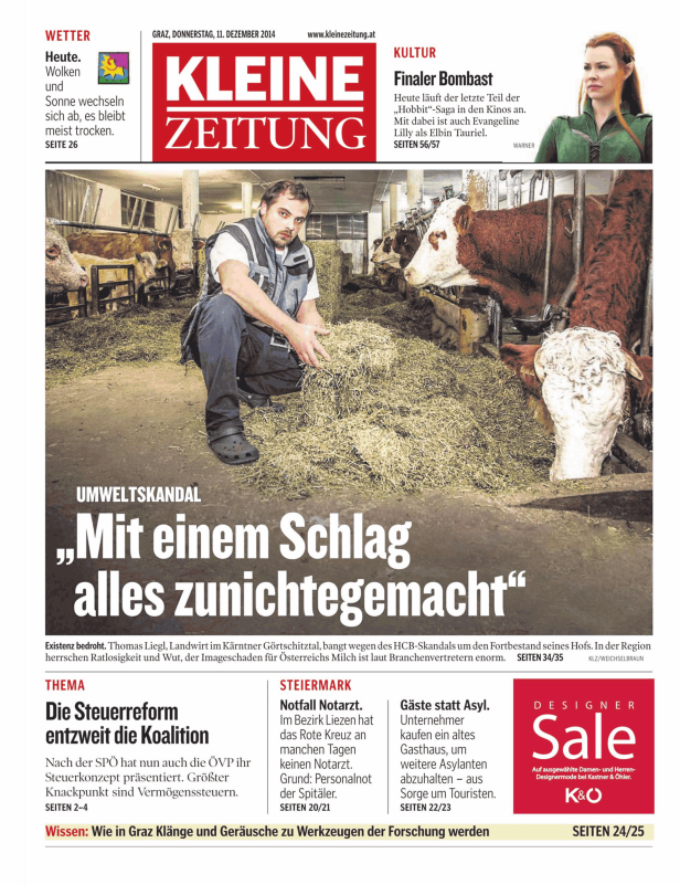 Ein Landwirt füttert Kühe mit Heu in einem Stall.