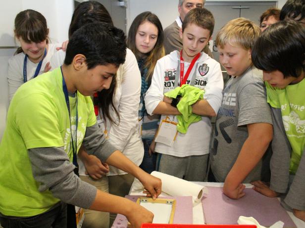 Eine Gruppe Kinder nimmt an einem Workshop zur Papierherstellung teil.