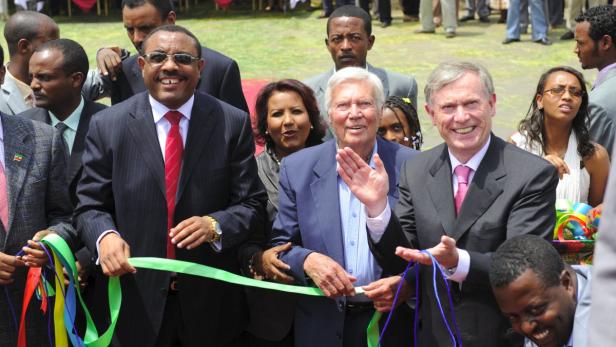 Mehrere Personen schneiden gemeinsam ein grünes Band durch.