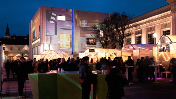 Das Leopold Museum in Wien ist abends von Menschen umgeben.