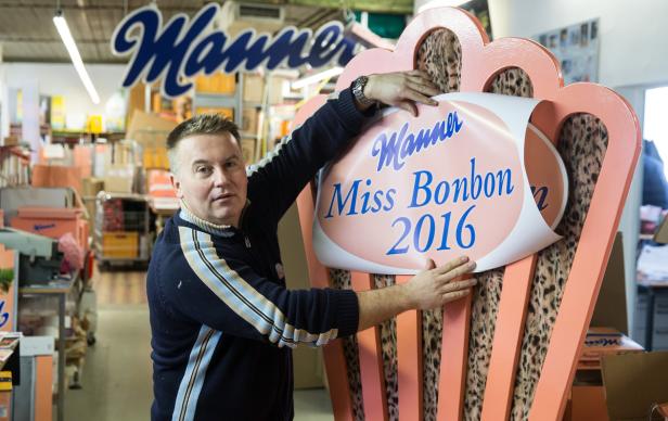 Ein Mann befestigt ein Schild mit der Aufschrift „Manner Miss Bonbon 2016“.