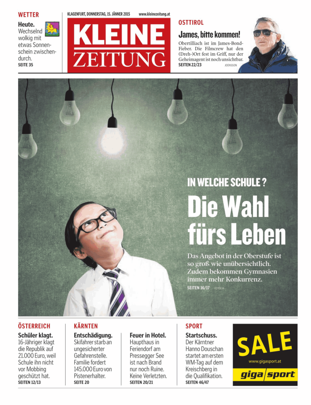 Ein nachdenklicher Junge mit Brille blickt zu hängenden Glühbirnen auf.