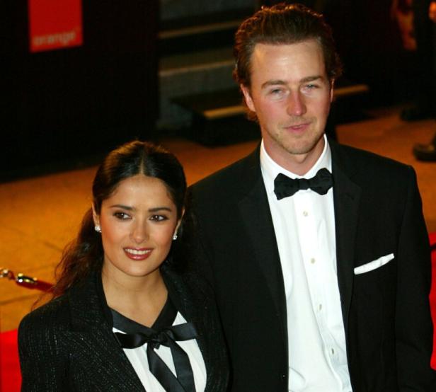 Salma Hayek und Edward Norton posieren auf einem Event in formeller Kleidung.