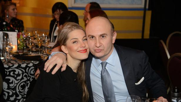 Eine Frau und ein Mann posieren lächelnd bei einer Veranstaltung.