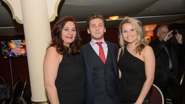 Drei Personen posieren für ein Foto bei einer Veranstaltung.