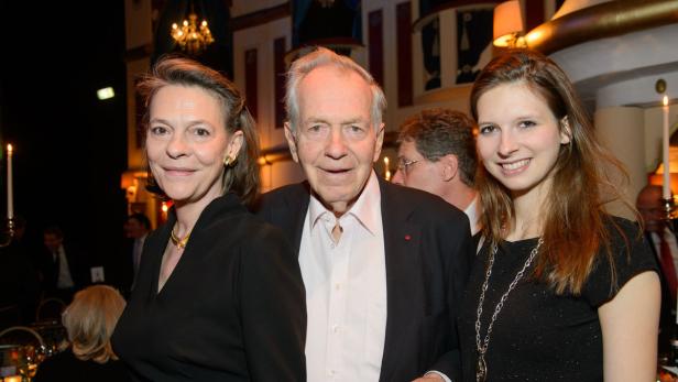 Drei Personen posieren auf einer Veranstaltung für ein Foto.