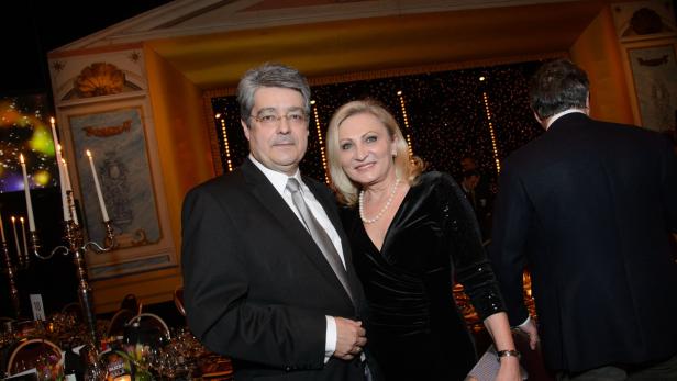 Ein Mann im Anzug und eine Frau im Abendkleid posieren auf einer Gala.