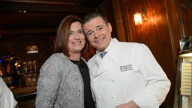 Eine Frau und ein Koch im Minoriten Stüberl lächeln in die Kamera.