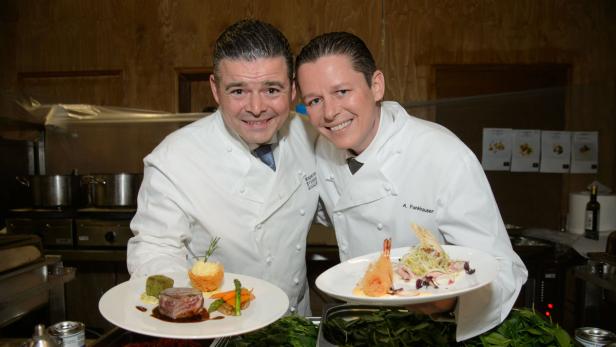 Zwei Köche präsentieren stolz ihre kulinarischen Kreationen.