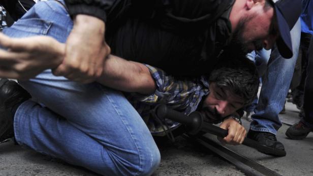 Ein Mann wird von einem anderen Mann zu Boden gebracht.