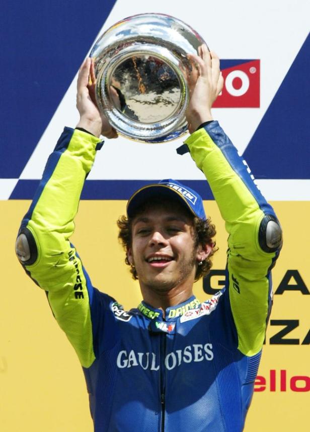 Valentino Rossi hält einen silbernen Pokal in die Höhe.