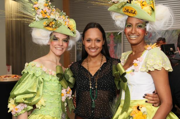 Drei Frauen posieren in fantasievollen, blumengeschmückten Kostümen für ein Foto.