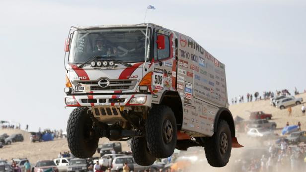 Ein Hino 500 Renntruck mit der Startnummer 508 springt über eine Sanddüne.