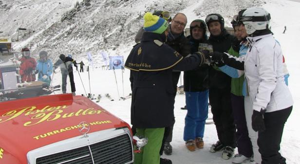 Eine Gruppe von Skifahrern stößt mit Gläsern vor dem „Pisten Butler“ auf der Turracher Höhe an.
