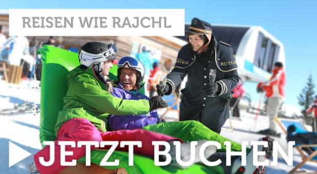 Zwei Personen entspannen auf einer Luftmatratze im Schnee, während ein Butler Champagner serviert.
