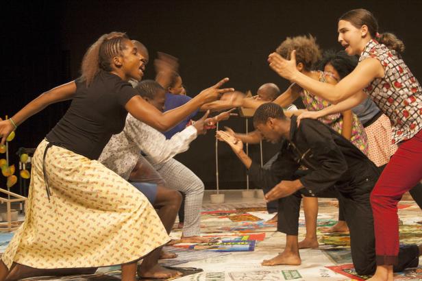 Eine Gruppe von Tänzern führt eine energiegeladene Performance auf einer Bühne auf.