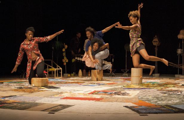 Mehrere Tänzerinnen treten auf einer Bühne mit einem Patchwork-Boden auf.