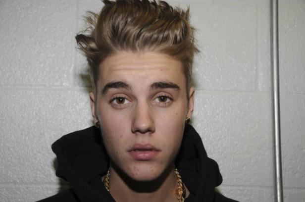 Ein Porträt von Justin Bieber mit blonden Haaren und einer goldenen Halskette.