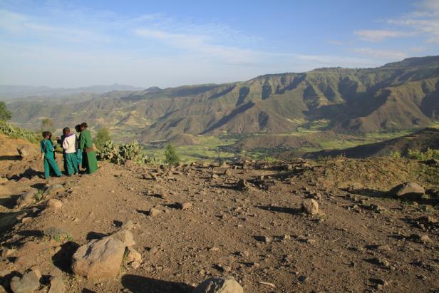 Eine Gruppe Kinder steht auf einem Hügel und blickt auf die grüne Landschaft Äthiopiens.