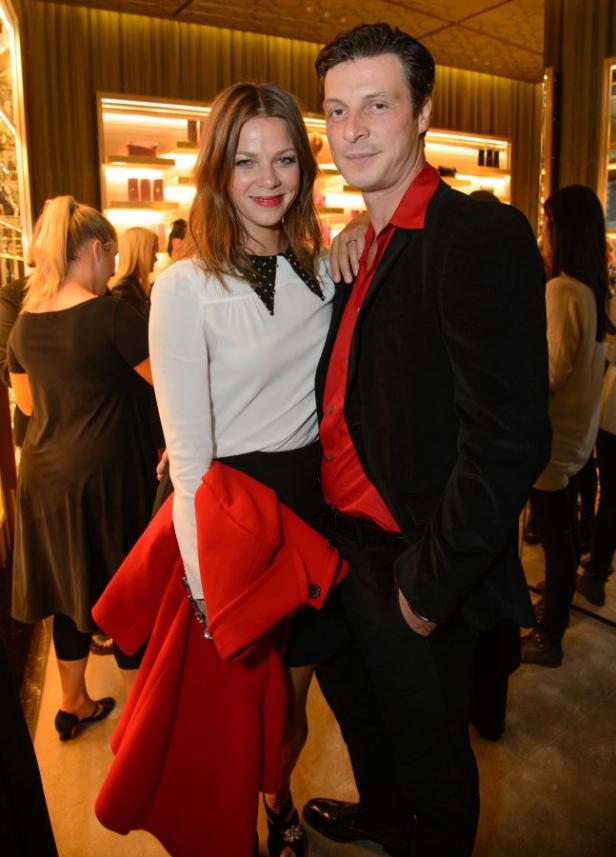 Eine Frau mit weißer Bluse und ein Mann mit rotem Hemd posieren für ein Foto.