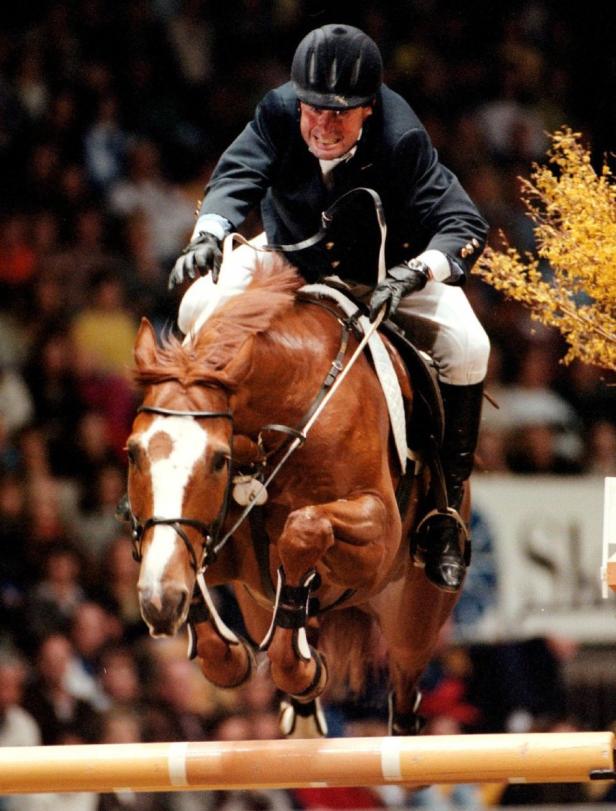 Ein Reiter springt mit seinem Pferd über ein Hindernis.