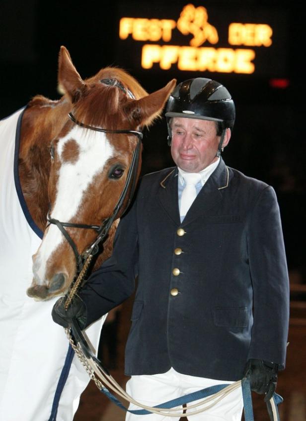 Ein Reiter mit Helm steht neben seinem Pferd bei „Fest der Pferde“.