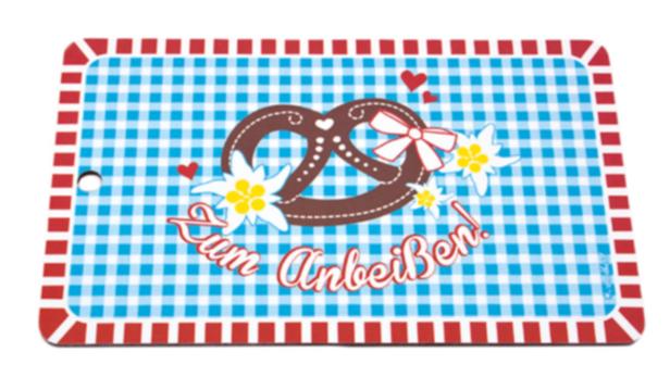Ein bayerisches Brotzeitbrett mit Brezel, Edelweiß und dem Schriftzug „Zum Anbeißen!“.