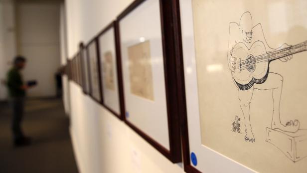 Eine Ausstellung zeigt eine Zeichnung eines Mannes, der Gitarre spielt.