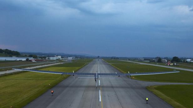 Ein Solarflugzeug steht auf einer Landebahn bei Dämmerung.