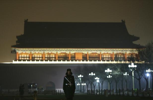 Ein Soldat steht vor dem beleuchteten Tiananmen-Tor in Peking.