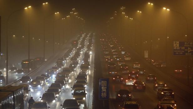 Starker Verkehr auf einer Autobahn in Peking bei Smog und schlechter Sicht.