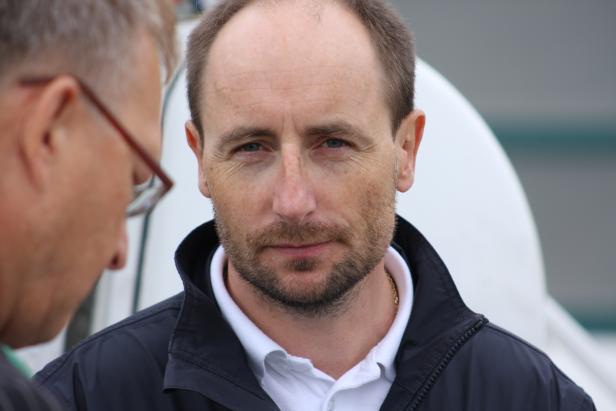 Porträt eines Mannes mit Bart und blauen Augen.